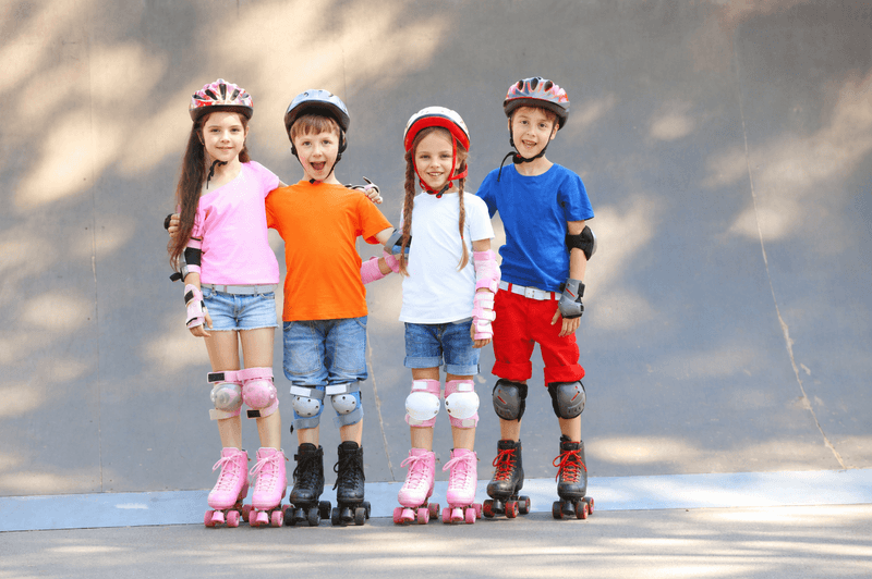 Children wearing helmets and skates before a roller skating program